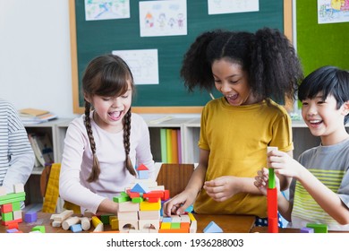 Group Of Diversity Of School Students Playing Wooden Blocks In Classroom. Elementary School Children Enjoy Learning Together. Learn To Work As A Team. Back To School Concept