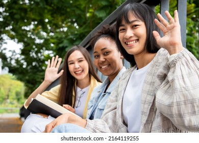 Group Of Diversity Women With Happy College Friends In Background At The Summer Park. Multiethnic And Student Doing Homework And Submit Assignments To Teachers. Learning Outside Classroom Concept