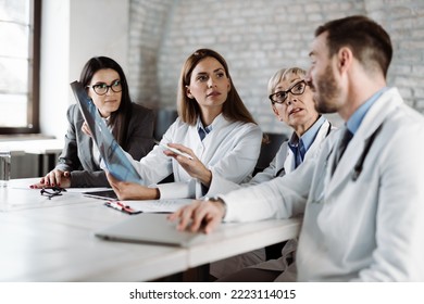 Group of doctors analyzing medical scan with businesswoman  in the hospital - Shutterstock ID 2223114015