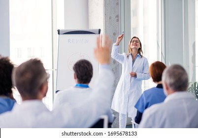 Group Of Doctors On Conference, Medical Team Sitting And Listening To Presentation.