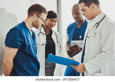 Group of doctors reading a document in meeting room at hospital - Powered by Shutterstock