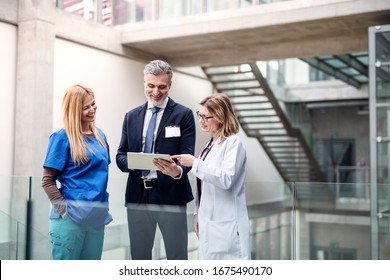 Group of doctors talking to pharmaceutical sales representative.