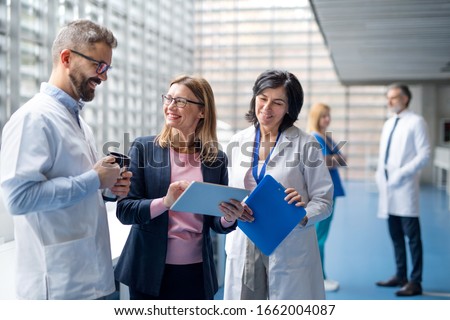 Group of doctors talking to pharmaceutical sales representative.