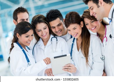 Group Of Doctors Using Health App On A Tablet Computer 