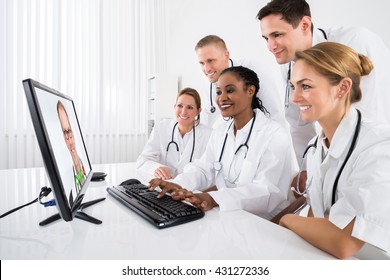 Group Of Doctors Videoconferencing On Computer In Hospital