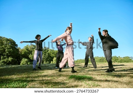 Group doing dance exercise in an autumn park with sunlight