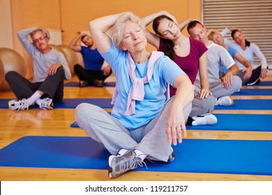 Group doing stretching exercises in back training class in a fitness center - Powered by Shutterstock