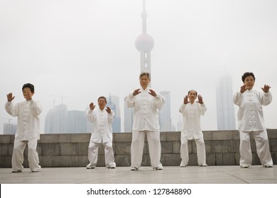 Group Doing Tai Chi Outdoors With City Skyline In Background