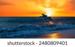 Group of dolphins jumping on the sea wave at sunset 