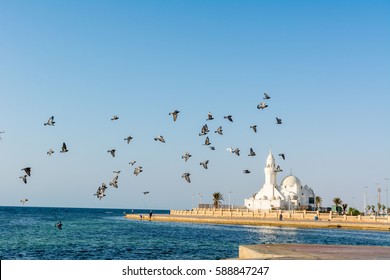 A Group Of Doves Flying Over White Mosque At The Jeddah Corniche Coastal Resort Park Near Red Sea In Jeddah, Kingdom Of Saudi Arabia, 