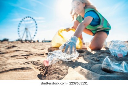 Group of eco volunteers picking up plastic trash on the beach - Activist people collecting garbage protecting the planet - Ocean pollution, environmental conservation and ecology concept - Powered by Shutterstock