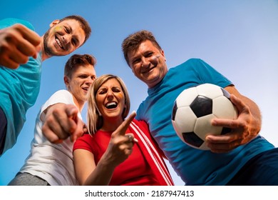 Group Of Ecstatic Fans Hugging Together , View From Bellow, Sky Background . Face Paint On, Fun Mode On!