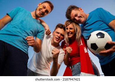 Group Of Ecstatic Fans Hugging Together , View From Bellow, Sky Background . Face Paint On, Fun Mode On!