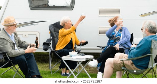 Group of elderly friends, men and women, enjoying drinks outside a camper. Elderly friends, men and women, having fun by a camper. Elderly friends, drinks. Senior friends vacation travel camper van - Powered by Shutterstock