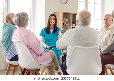 Group of elderly men and women sitting in a circle in nursing home with friendly young nurse and listening each other during psychological therapy in session. Psychotherapy for senior people. - Powered by Shutterstock