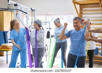 Group of elderly people doing workout in fitness class with instructor - Powered by Shutterstock