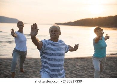 group elderly of people practice Tai Chi Chuan  at sunset on the beach.  Chinese management skill Qi's energy. Healthy lifestyle  - Powered by Shutterstock