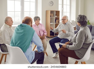 Group of elderly people talking on therapy session at nursing home. Senior men and women sitting in circle and having conversation and discussing some problems together. Psychotherapy concept. - Powered by Shutterstock