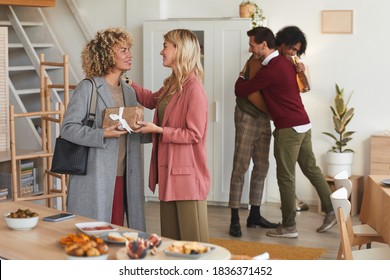 Group Of Elegant Adult People Greeting Each Other And Exchanging Gifts While Welcoming Guests At Dinner Party Indoors