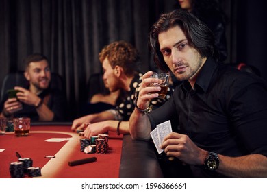 Group of elegant young people that playing poker in casino together.