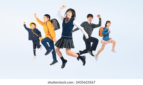 A group of elementary, junior high school, and kindergarten children jumping.