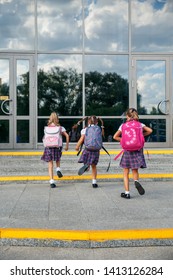 Group Of Elementary School Kids Running At School, Back View