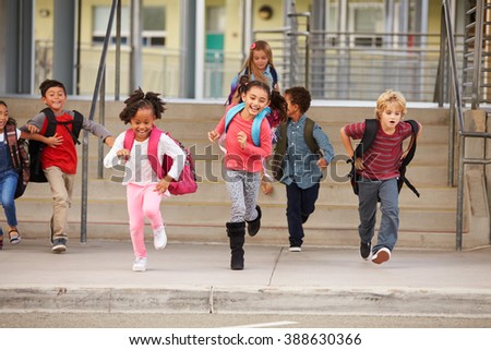 A group of elementary school kids rushing out of school
