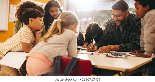Group of elementary school kids stand around a table in a classroom, attentively following a lesson being taught by their teacher. Young students engaging in a fun activity of colouring and drawing.