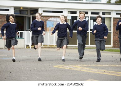 Group Of Elementary School Pupils Running In Playground