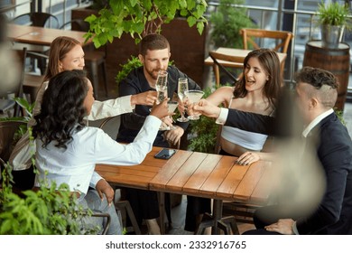 Group of employees, colleagues meeting at cafe after work, celebrating successful deal, drinking champagne and cocktails. Concept of leisure time, business, communication, fun, alcohol drink - Powered by Shutterstock