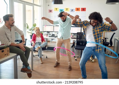 A group of employees is having fun while playing with hula-hoop in a relaxed atmosphere in the office. Employees, job, office