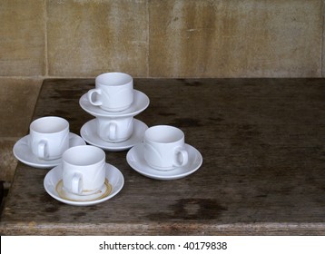 A group of empty coffee cups for espresso and saucers on the kitchen table
