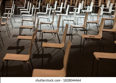 Group Of Empty White Chairs Arranged For Social Distance During An Indoor Business Event. COVID-19 Health And Safety Measures During Pandemic Require Spacing Between People