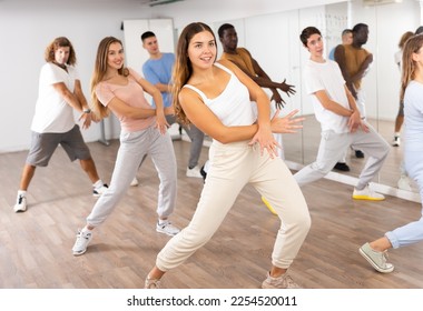 Group of energetic different people learning dance at dance class - Powered by Shutterstock