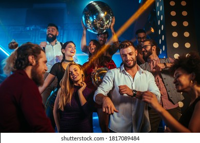 Group of energetic young people dancing at a party in a nightclub - Powered by Shutterstock