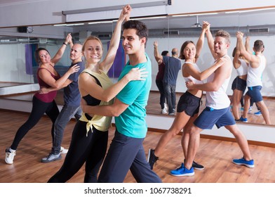 Group Of Energy People Dancing Salsa Together In Dance Studio And Smiling