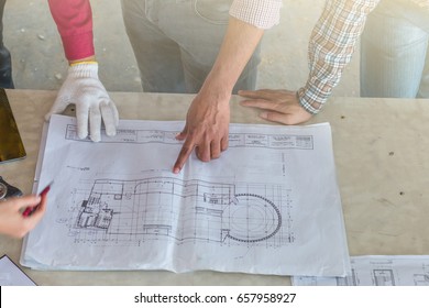 Group of engineer checking the blueprint on the table and talking about construction project with commitment to success at construction site