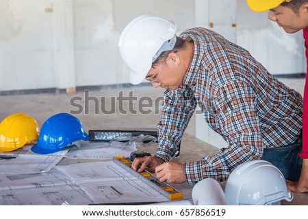 Group of engineer checking the blueprint on the table and talking about construction project with commitment to success at construction site