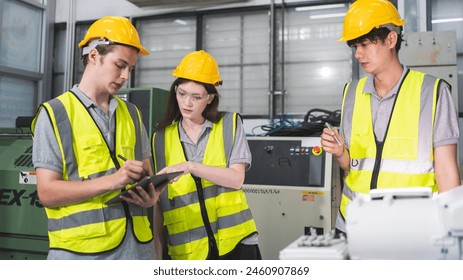 A Group of engineer are examining machine robot arm with smart tablet. Installation indoor industrial factory. Technician coworker check for repair maintenance electronic operation with remote system