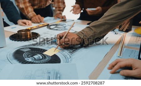 A group of engineers engaged in a collaborative session focusing on technical drawings of mechanical components, showcasing hands-on work with precision tools and detailed planning. SACTR