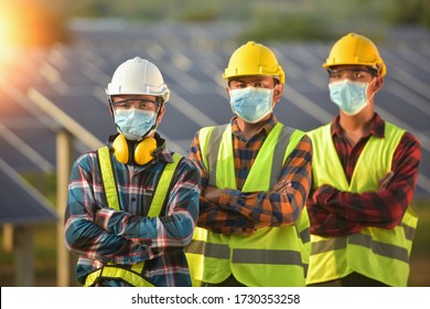 Group Of Engineers Meeting On Building Roof.solar Engineer And Electrician With Face Mask Checking And Resolve Problem Of Generate Power In Solar Power Plant.