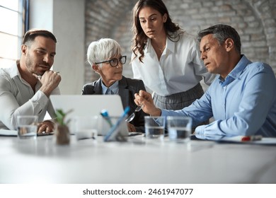 Group of entrepreneurs cooperating while working on a computer in the office - Powered by Shutterstock