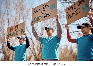 Group Of Environmentalist Participating In  Global Climate Change Protest And Carrying Paperboards With Different Messages.