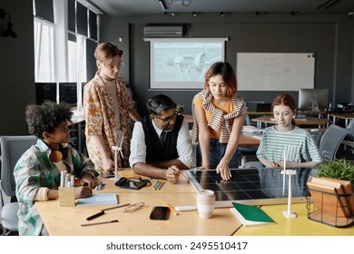 Group of ethnically diverse teen boys and girls learning about solar energy and PV modules during Environmental Education lesson - Powered by Shutterstock