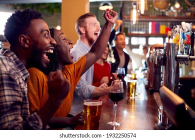 Group Of Excited Customers In Sports Bar Watching Sporting Event On Television - Shutterstock ID 1932250574