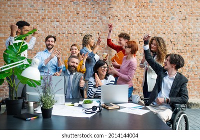 Group of excited entrepreneurs working on project indoors in office, celebrating successful contract. - Powered by Shutterstock