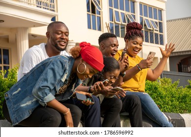 group of excited young black people using their phones - Powered by Shutterstock