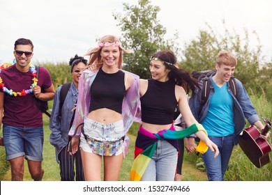 Group Of Excited Young Friends Carrying Camping Equipment Through Field To Music Festival - Shutterstock ID 1532749466