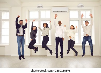 Group Of Excited Young People Jumping For Joy Together. Intercultural Team Of Happy Friends, Cheerful Students, Business Startup Members Or Office Coworkers Celebrating Collaboration And Success