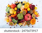 Group of Exotic fruits including, rose kiwi, pomegranate, passion fruit, cherimoya, Tamarillo, tiger lemon, Custard Apple, kumquat, red apple. Unusual tropical fruits on white textured background.